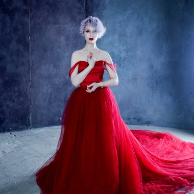 Kırmızı elbiseli genç muhteşem kadın moda fotoğrafı. Dokulu arka plan