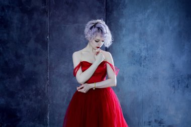Kırmızı elbiseli genç muhteşem kadın moda fotoğrafı. Dokulu arka plan