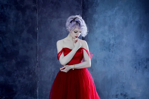 Foto de moda de la joven mujer magnífica en vestido rojo. Fondo texturizado —  Fotos de Stock