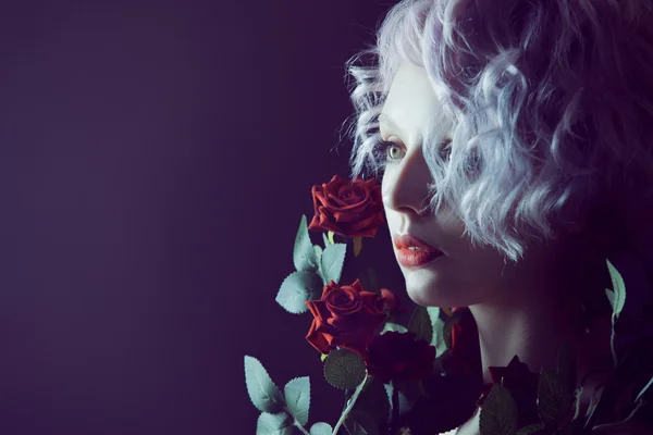 Fashion photo of young magnificent woman with red roses. Textured background. — Stock Photo, Image