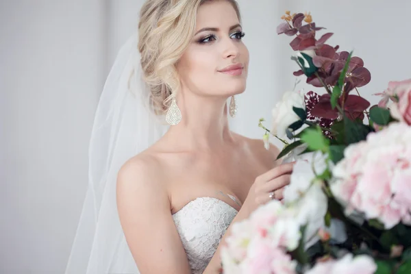 Charmante junge Braut im luxuriösen Hochzeitskleid. hübsches Mädchen, das Fotostudio — Stockfoto