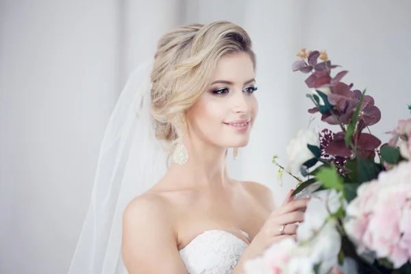 Charmante junge Braut im luxuriösen Hochzeitskleid. hübsches Mädchen, das Fotostudio — Stockfoto