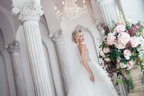 Charmante junge Braut im luxuriösen Hochzeitskleid. hübsches Mädchen, das Fotostudio — Stockfoto