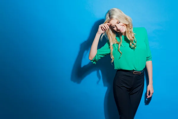 Porträtt av unga säker blondin, casual stil, blå bakgrund — Stockfoto