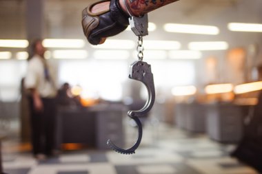 Criminal man. Hand male in unbuttoned handcuffs, on background of the police station clipart