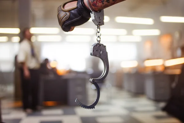 Criminal man. Hand male in unbuttoned handcuffs, on background of the police station — Stock Photo, Image