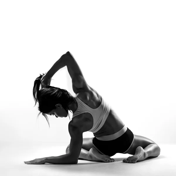 Muscular female body. Young strong athlete posing on grey background. Black-and-white contrast photo — Stock Photo, Image