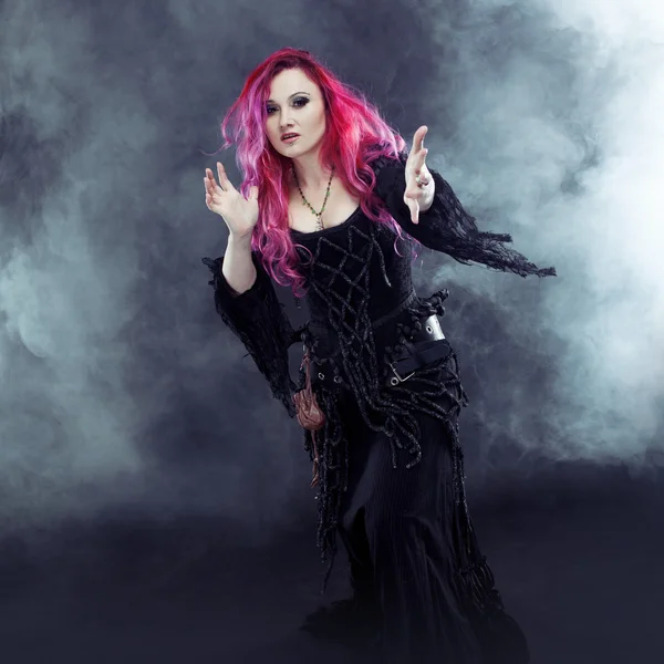 Halloween czarownica tworzy magii. Atrakcyjna kobieta z rude włosy w stroju wiedźmy — Zdjęcie stockowe
