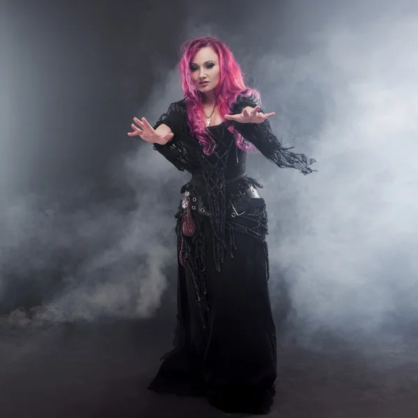 ハロウィーンの魔女は、魔法を作成します。赤い髪と魔女の衣装で魅力的な女性 — ストック写真