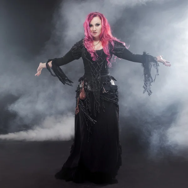 La Strega di Halloween crea magia. Donna attraente con i capelli rossi in costume streghe — Foto Stock