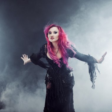 Halloween cadı magic oluşturur. Çekici kadın Kızıl saçlı cadı kostüm uzanmış silah, güçlü Rüzgar ayakta