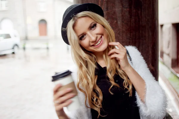Веселая женщина на улице пьет утренний кофе. Ходячая девушка — стоковое фото