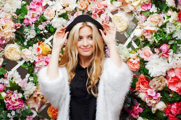 Young beautiful blonde woman in fashionable hat on floral background — Stock Photo, Image