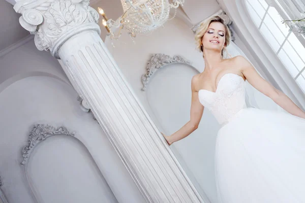 Charmante junge Braut im luxuriösen Hochzeitskleid. hübsches Mädchen, das Fotostudio — Stockfoto