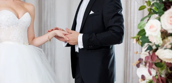 The groom holds the brides hand, wedding vows.