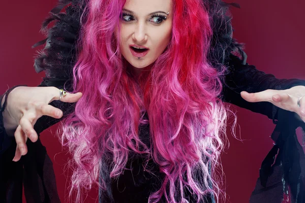 Bruja asustadiza con el pelo rojo realiza magia. Halloween . — Foto de Stock
