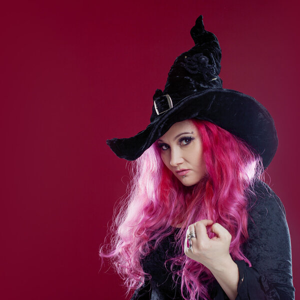 Привлекательная женщина в шляпе и костюме ведьмы с рыжими волосами. Хэллоуин
