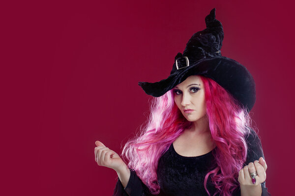 Привлекательная женщина в шляпе и костюме ведьмы с рыжими волосами. Хэллоуин
