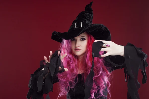 Mulher atraente em chapéu de bruxa e traje com cabelo vermelho. Halloween. — Fotografia de Stock