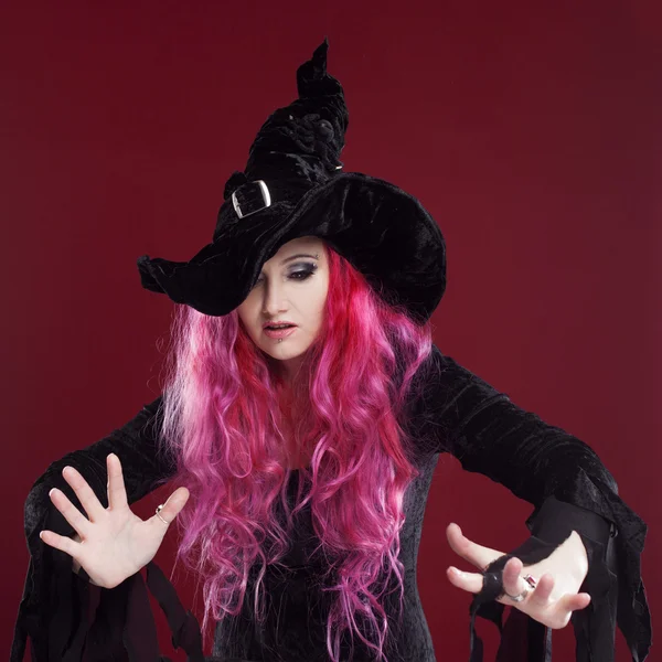 Mulher atraente em chapéu de bruxa e traje com cabelo vermelho. Halloween. — Fotografia de Stock