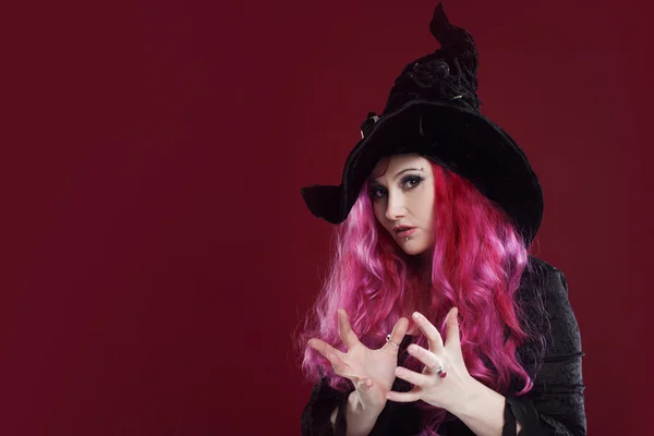 Mujer atractiva en sombrero de brujas y traje con pelo rojo. Halloween — Foto de Stock