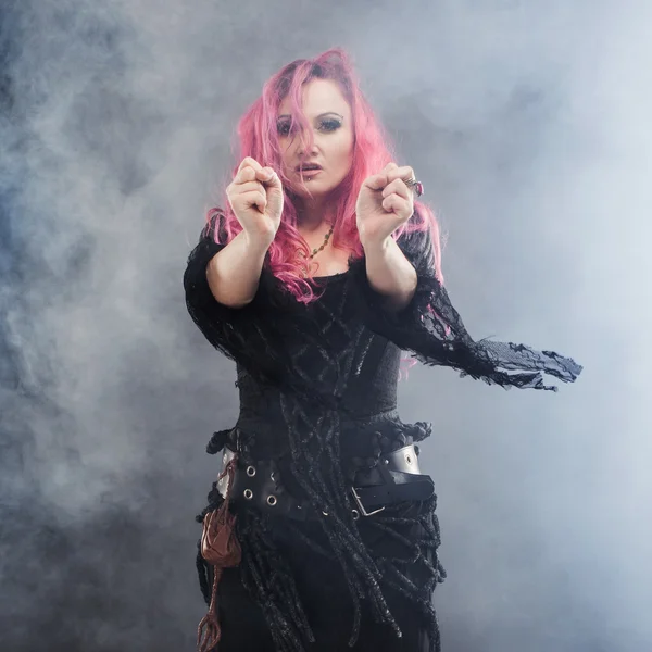Witch vytváří magie. Atraktivní žena s rudými vlasy v čarodějnice kostým — Stock fotografie
