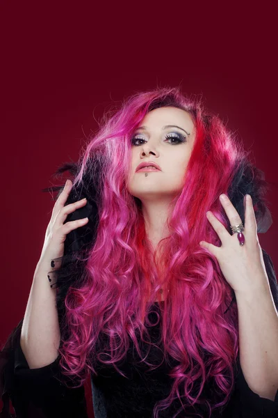 Attraktiv kvinna med rosa hår i häxa bild. Halloween stil — Stockfoto