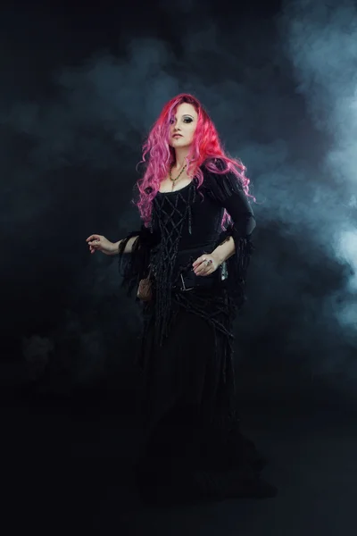 Hexe zaubert. attraktive Frau mit roten Haaren im Hexenkostüm — Stockfoto