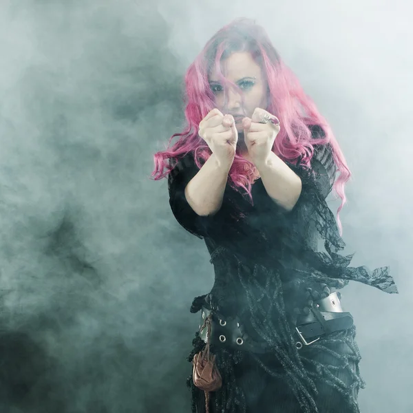 La strega crea magia. Donna attraente con i capelli rossi in costume streghe — Foto Stock