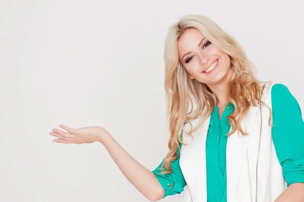 Retrato de joven rubia feliz, estilo casual, fondo blanco. Sostiene algo en la palma — Foto de Stock