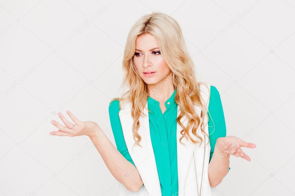 Portrait young happy blonde, casual style, white background. Emotion of puzzling