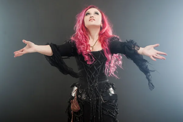 ハロウィーンの魔女は、魔法を作成します。赤い髪と両腕、強い風に立って魔女衣装で魅力的な女性 — ストック写真