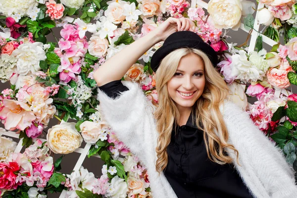 Joven hermosa mujer rubia en sombrero de moda sobre fondo floral — Foto de Stock