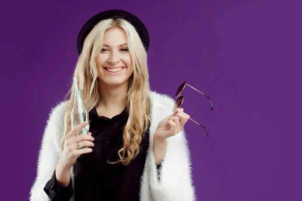 Jeune belle femme blonde au chapeau à la mode. Boire du soda dans des bouteilles en verre. Très heureux — Photo