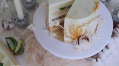 Kremalı ve kivili güzel bir düğün pastası, masa düzenleme ve tabakta bir dilim pasta..