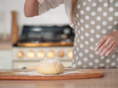 Diz hamuru, el hamuru ve un yakın plan. Gri benekli önlüklü bir pasta şefi..