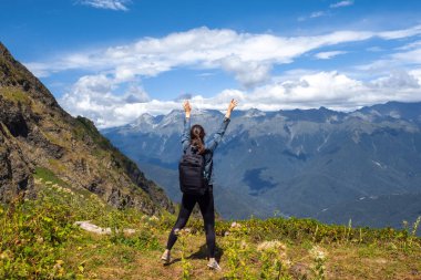Dünyayı kucakla. Dağlarda seyahat eden mutlu genç kadın..