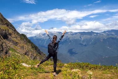 Doğayla bütünleşme, dağlarda genç bir bayan turist. Ufka sarılmak için kollarını aç..