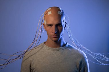 Kafasında elektrotlar olan bir adam gelecekteki sanal gerçeklik ve zihin kontrolü kavramı..