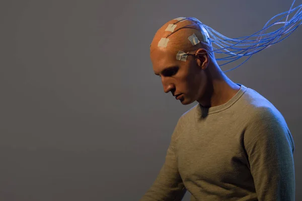 Mann mit Elektroden im Kopf ist ein futuristisches Konzept für virtuelle Realität und Gedankenkontrolle. — Stockfoto