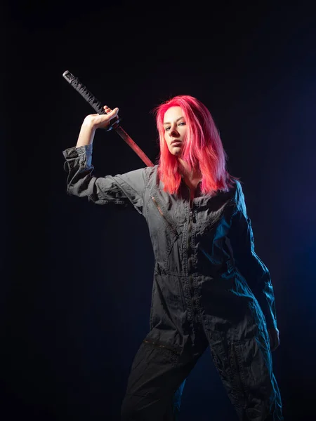 Cyberpunk and futurism, concept. A young woman with pink hair and overalls, a samurai mercenary with a katana. — Stock Photo, Image