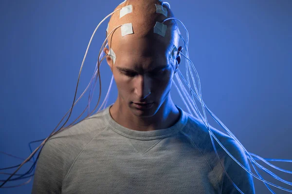 Άνθρωπος με ηλεκτρόδια στο κεφάλι του είναι μια φουτουριστική έννοια της εικονικής πραγματικότητας και του ελέγχου του νου. — Φωτογραφία Αρχείου