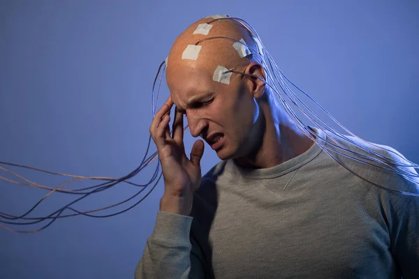 Un hombre con una cabeza calva con cables conectados. Miedo y ansiedad. Examen del cerebro, —  Fotos de Stock