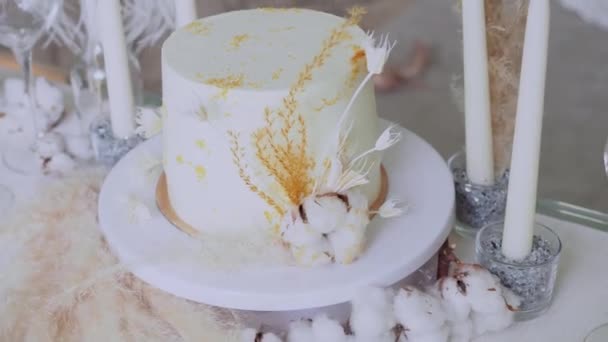 Prachtige bruidstaart met room en kiwi, tafel zetting en een stuk taart op een bord. — Stockvideo