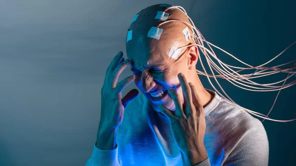 Человек с имплантатами в голове испытывает стресс и ужас. Новые технологии, расширенный мозг, — стоковое фото
