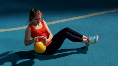 Genç bayan sporcu antrenman yapıyor, açık havada bir su ısıtıcısıyla antrenman yapıyor..