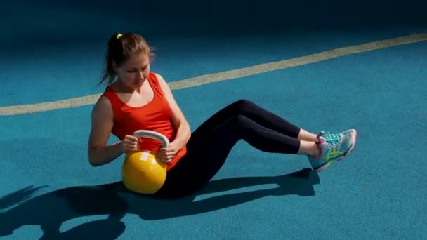 Mladá sportovkyně dělá cvičení, trénink s kettlebell pod širým nebem. — Stock video