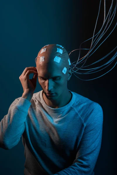 Man met elektroden in zijn hoofd is een futuristisch concept van virtual reality en mind control. — Stockfoto