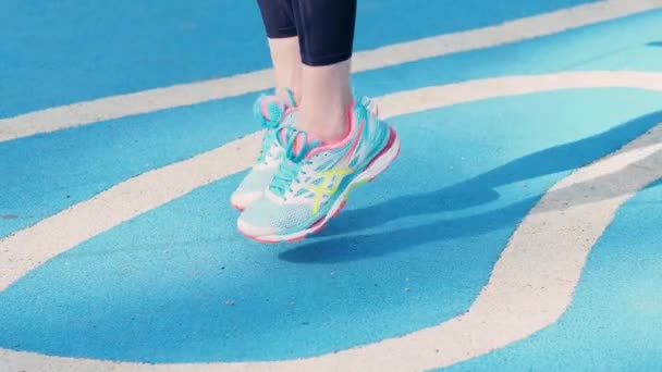 Mladá atletka dělá venkovní cvičení. Jump rope, cardio warm-up — Stock video