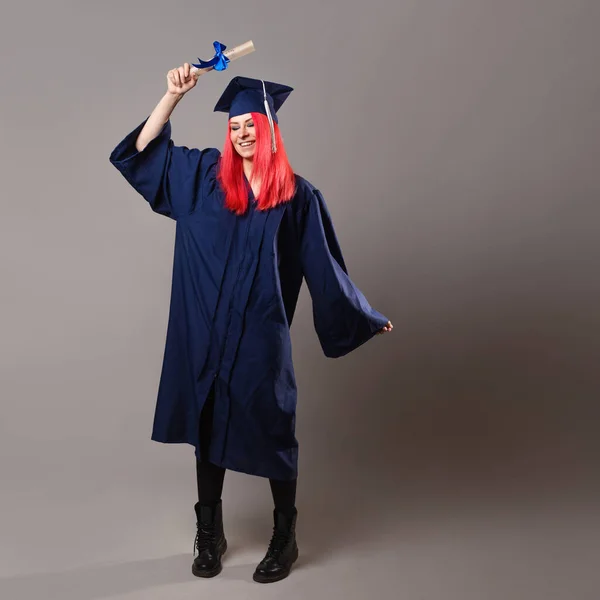 young woman is a university graduate. Happy graduate master in a robe and cap,